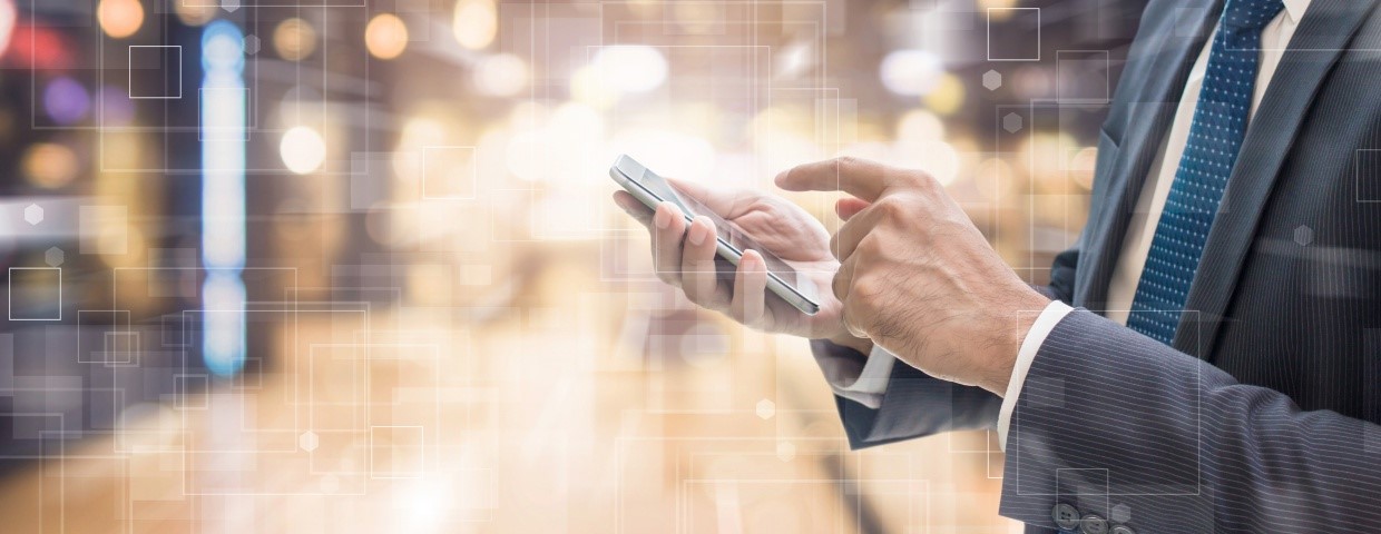 Business applications increasingly Mobile Businessman in a datacenter with a smartphone in his hands