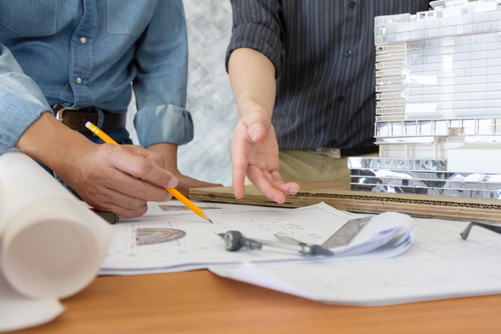 Two construction engineer interacting on some project documents